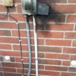 Burnt AC disconnect box with fire and soot damage on a Houston home — electrical failure caught by Texas Star Heating & Cooling before it caused a house fire