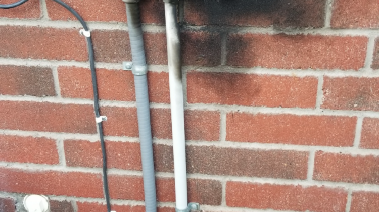 Burnt AC disconnect box with fire and soot damage on a Houston home — electrical failure caught by Texas Star Heating & Cooling before it caused a house fire